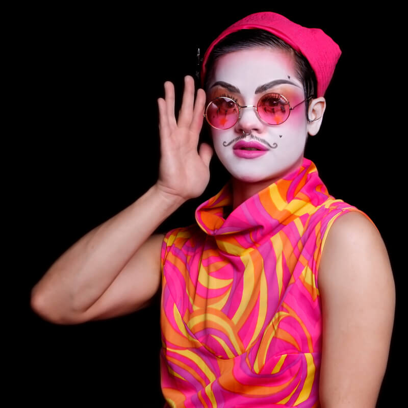 Rose in a 60's style pink-and-yellow dress and pink hat.